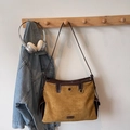 Detail of ginger suede dumpling bag with dark brown leather trim and metal fashion logo - Yellowish Brown Without Pendant