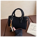 Close-up of black suede crossbody bag featuring wooden bead pendant and metal hardware - Black with Pendant