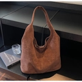 Detail of deep brown suede tote bag with vertical stitching on a minimalist shelf - Coffee