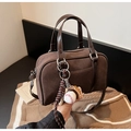 Detailansicht der braunen Wildleder-Boston-Tasche mit Baseball-Anhänger und Lederhandgriff - Kaffee mit Anhänger
