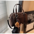 Detail of dark brown suede Boston bag with a mini baseball glove charm and leather handles - Coffee with Pendant