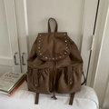 Détails d'un sac à dos en daim marron avec rivets argentés et fermeture à cordon - Marron