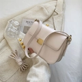 Cream white minimalist leather crossbody bag with matte gold buckle on a textured coat - Off White