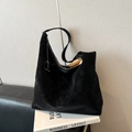 Grande borsa tote in pelle scamosciata nera con tracolla su sfondo di libri - Nero