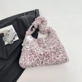 Pink leopard print plush tote bag with a white fuzzy ball pendant on a grey blazer - Spot Pink