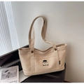 Dettaglio della borsa tote in tela beige con ricamo di ragazza e scritta Docile girl - Cachi