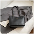 Close-up of black leather tote bag with gold lettering on a grey blazer background - No Pendant / Black