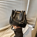 Glossy black bucket bag with gold chain strap and elegant metallic hardware details - Black