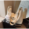 Λεπτομέρεια κρεμ δερμάτινης τσάντας ώμου με πτυχώσεις, λούτρινο γούρι και ασημί στοιχεία - Σπασμένο Λευκό