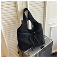 Dettaglio borsa tote in denim nero con tasche a cerniera e nappine decorative - Nero