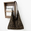 Detalle de un bolso de ante con estampado de leopardo colgado en un gancho de madera de pared - Estampado de leopardo marrón grande