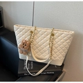 Detail of white quilted tote bag with metal chain strap and cute brown plush bear charm - Cream White With Pendant