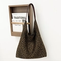 Detalle del bolso tipo cubo de ante con estampado de leopardo y correa de cuero en soporte - Leopardo Pequeño Marrón