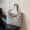 Quilted light gray tote bag with adjustable strap on a sofa, large capacity design - Gray