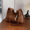 Borsa tote in pelle marrone con nappe in legno in un ambiente accogliente e caldo - Marrone