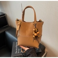 Détail du sac seau marron avec textures en daim mat et décoration de breloque en bois - Avec Pendentif / Kaki
