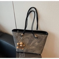 Détail d'un grand sac cabas gris texturé avec bandoulières noires et charme en peluche - Noir avec pendentif