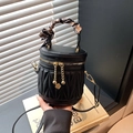 Quilted black cylinder bucket bag with silk scarf handle and gold floral charms - Black