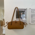 Detailed close-up of a brown tote bag with decorative side knots and double zippers - Brown