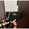 Detail der schwarzen Wildledertasche mit goldenem Logo und verstellbarem Schultergurt - Schwarz
