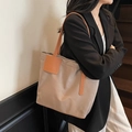 Beige nylon tote bag with brown leather straps shown on shoulder for daily commute - Khaki