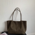 Detalle de bolso tote minimalista de ante marrón café con costuras verticales y asas largas - verde oliva