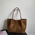 Detail shot of brown suede tote bag featuring slim shoulder straps and vertical seam - Brown