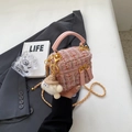 Mini sac seau en tweed rose avec bandoulière chaîne et charme peluche tenu par mannequin - Petit / Rose Petit