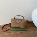Detalle del bolso de ante con costuras de cuero, cremallera metálica y asa curva elegante - Gamuza Marrón