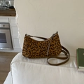 Detail der hobo-tasche mit leopard-print, braunem lederriemen und strukturierter stoffoberfläche - Leopardenmuster