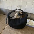 Vue détaillée du sac hobo en daim noir avec boucle argentée sur table en bois - Noir