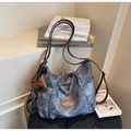 Détail du sac fourre-tout en jean bleu avec texture vintage et logo en cuir marron - Bleu Ciel