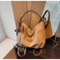Détail du sac hobo kaki avec anses en cuir et breloques décoratives en nœud et cœur - Khaki