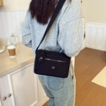 Minimalistische schwarze Nylon Umhängetasche mit mehreren Reißverschlüssen am Model - Schwarz