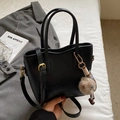 Retro black bucket bag in matte leather with gold hardware and plush ball charm - Black