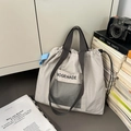 Détail du sac cabas en nylon gris clair avec poche en filet noir et sangle bleue - Gris clair