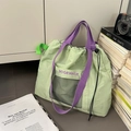 Détail du sac fourre-tout vert clair avec sangles violettes et poche en filet noir - Vert