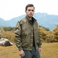 Men's olive green tactical bomber jacket with military patches in a rugged outdoor setting - S / Khaki