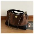 Détail macro du sac en daim matelassé marron et cuir noir avec fermoir doré élégant - Marron