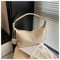 Detailansicht der beigen geflochtenen Ledertasche mit silbernem Reißverschluss und Anhänger - Gebrochenes Weiß