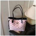Dettaglio della borsa tote rosa a pois con motivi a fiocco nero e placca logo in metallo - Rosa