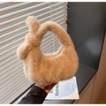 Detailed close-up of soft beige plush handbag featuring a unique knotted handle design - Light Khaki