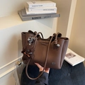 Donkerbruine tote bag van generfd leer met geknoopte schouderriem en pluche beer-bedel - Koffie met Hanger