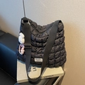Schwarze gesteppte Puffer-Tasche mit breitem Gurt und weißem Plüsch-Hasen-Anhänger - Mit Anhänger / Schwarz