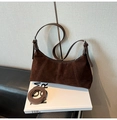 Macro detail of dark brown suede shoulder bag with leather strap on a decorative book - Coffee without Pendant