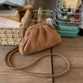 Bolso nube de ante marrón con textura plisada y correa sobre mesa de madera - Marrón