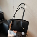 Black woven texture shoulder bag with gold logo and wooden beaded charm detail - Black