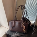Deep brown woven leather shoulder bag with chic wooden bead charm and gold logo - Brown