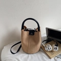Camel suede bucket bag with black leather handles and shoulder strap on white desk - Khaki No Pendant