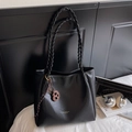 Borsa tote nera retrò intrecciata con un ciondolo a forma di biscotto marrone in posa - Nero con ciondolo
